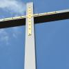 Die goldene Auflage wurde vom alten Holzkreuz übernommen. So strahlt auch das neue Rederkreuz im Sonnenschein.