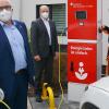 Zwei Elektro-Fahrzeuge können an der neuen Schnellladesäule an der Sparkasse in Bad Königshofen ihre Batterien aufladen. Sparkassendirektor Georg Straub (vorne), sowie Gebietsdirektor Peter Lindemann und Nachhaltigkeitsbeauftragter Wolfgang Sauer (rechts) nahmen die neue E-Ladesäule nun offiziell in Betrieb.