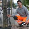 Sebastian Schmitt, Stadtgärtner der Stadt Marktheidenfeld, begutachtet einen Schaden an einem Baumschutzgitter in der Kreuzbergstraße.