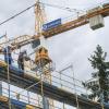 Der Polier (rechts) wirft beim Richtfest für die neue Modellfabrik des SKZ im Gewerbegebiet Ost in Würzburg ein Weinglas vom Dach.