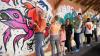 Farbenfrohes Teamwork: Künstlerin Ronni Zettner (Mitte, dunkles Kleid) hat gemeinsam mit Kindern und Jugendlichen eine meterlange Wand im Haus Marienthal in ein Streetart-Kunstwerk verwandelt – initiiert und finanziert vom Rotary Club Schweinfurt Friedrich Rückert. Im Bild schwingen Rotary-Past-Präsidentin Sabine Fehn (links) und Oliver Schulte den Pinsel für den fröhlich-bunten guten Zweck.