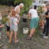 Mit großem Interesse verfolgten die Kinder das Binden von Kräutersträußchen beim Frauenbund Hofheim. Im Hintergrund Pfarrvikar Ninh.