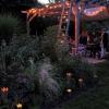 Die Gäste genießen die Stimmung zur blauen Stunde im mehrfach ausgezeichneten Naturgarten der Familie Scheder in Lülsfeld.