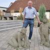 Peter Pfister am Dorfbrunnen in der Ortsmitte vor der Kirche und dem Rathaus, dessen Umgriff aus dem Erlös der 950-Jahr-Feier mit Steinfiguren ausgestattet werden konnte.