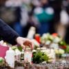 25.01.2022, Baden-Württemberg, Heidelberg: Menschen legen vor einem Gebäude der Universität Blumen und Kerzen an den Wegesrand. Gestern war ein 18 Jahre alter Student mit einer Schrotflinte bei laufender Vorlesung in den Hörsaal des Gebäudes gestürmt und hatte um sich geschossen. Eine junge Frau starb, der Täter tötete sich wenig später selbst. Foto: Uwe Anspach/dpa +++ dpa-Bildfunk +++