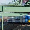 Das Zwei-Wege-Fahrzeugs ist im Hafen als Rangierlock auf den Schienen, auf Pflaster und Asphalt unterwegs und kann Waggons mit einem Gesamtgewicht von bis zu 6000 Tonnen ziehen. Über ihm sind die Stützen der Doppelwippkräne zu sehen.
