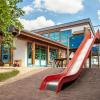 Im rechten Pflanzenbereich errichtet die Gemeinde Veitshöchheim einen zweigeschossigen Neubau für eine Regel- und eine Krippengruppe, der durch einen Glasgang mit dem bestehenden Kuratiekindergarten verbunden wird.