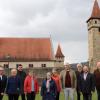Gerne stellten sich (von links) Anne Kraft (Bezirk Unterfranken), Ostheims Bürgermeister Steffen Malzer, der stellvertretende Landrat Bruno Altrichter, Adolf Büttner, Vorsitzender des Vereins "Freunde der Kirchenburg",  und Vertreter der Partnergemeinden zu einem Erinnerungsfoto vor der historischen Kulisse der Ostheimer Wehranlage.