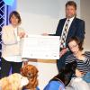 Der Präsident des Rotary Clubs Kitzingen, Friedrich Walther, überreicht bei der Soiree am Sonntagnachmittag einen Scheck in Höhe von 11.000 Euro an die Vorsitzende des Vereins Vita Assistenzhunde, Tatjana Kreidler (links), und Juliane mit Labrador Kermit.