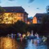 Erstmals mit LED-Lichtern: Der Lichterkorso auf der Saale mit einem Model der Gemündener Scherenburg vor der Kulisse des Huttenschlosses.