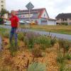 Von der mit  Blumen geschmückten östlichen Einfahrt von Riedenheim führt der Weg, den Bürgermeister Edwin Fries weist, auf den wenige Meter entfernt liegenden Erholungsplatz.