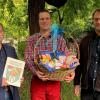 Übergabe von Urkunde und Geschenkkorb.