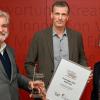 Ivo Knahn, Chefredakteur der Main-Post (Bildmitte), nimmt den Journalistenpreis "Medienspiegel" von Thomas Hauser (Vereinigung der Medien-Ombudsleute) und Sabine Roschke (Initiative Tageszeitung e.V.), entgegen.