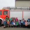 Der Kindergarten Trappstadt zusammen mit der Kommandant Florian Bauer links im Bild und Feuerwehrmann Moritz Werner rechts im Bild.