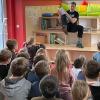 Schauspieler Anselm Müllerschön vom Mainfrankentheater Würzburg liest mit vollem Körpereinsatz vor und alle Kinder lauschen gespannt.