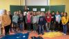 Die Klasse 3a präsentiert stolz das gemeinsam mit Pfarrer Thomas Amrehn gestaltete Bodenbild zum Thema "Gemeinsam einzigartig".