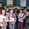 Die geflüchteten Kinder in der Grundschule Kleinlangheim freuen sich mit Schulleiterin Nicole Achter, hinten links und Monika Zehnder, hinten rechts, 2. Vorsitzende Zeit füreinander Wiesentheid, über das Material zum selbständigen Erlernen der deutschen Sprache.