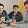 Hedayatullah Muslih, Muhammad Wafa und Sayed Eshag zeigen auf dem Handy, wie so ein Frühlingsfest an Neujahr in Afghanistan gefeiert wird. Da steht dann gutes Essen auf dem Tisch und alles ist geschmückt.