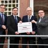 Das letzte Schild der Zensusstelle Main-Tauber-Kreis im ehemaligen Gerichtsgefängnis in Tauberbischofsheim wurde gemeinsam entfernt: Landrat Christoph Schauder (von rechts) mit Jörg Scheidel, bisheriger Leiter der Zensusstelle Main-Tauber-Kreis, Bernhard Blümm und Erstem Landesbeamten Florian Busch.