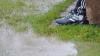 Auf einem Fußballplatz hat sich eine große Pfütze gebildet.