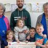 Das Foto zeigt Monika Schmied-Keß vom KDFB, Kindergartenleiter Michael Schindler, Barbara Lindner (KDFB) und Mädchen und Jungen des Kindergartens St. Johannes bei der symbolischen Scheckübergabe.
