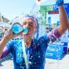 Wasser von vorne und Wasser von oben: Die Würzburgerin Carolin Lehrieder erfrischt sich, nachdem sie beim Trumer Triathlon im Salzburger Land als Erste angekommen ist.
