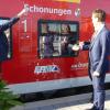 Marco Schimmich (DB, links), Landrat Florian Töpper und Bürgermeister Stefan Rottmann (spiegelt sich im Fenster) tauften eine Regionalbahn auf den Namen Schonungen.