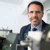 Ralf Diesslin ist seit etwa zwölf Jahren Geschäftsführer des Kerzenmaschinen-Herstellers Herrhammer. Im Hintergrund ist die erste Kerzenmaschine von Firmengründer Alfred Herrhammer zu sehen.