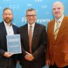 Johannes Bröstler (links) und Oliver Hauguth (rechts) vom Movie im Luitpoldhaus bekommt die Urkunde für den Filmprogrammpreis von Staatsminister Florian Hermann überreicht.