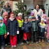 Kinder der Kita Baumhofstraße aus Marktheidenfeld mit (von links) Ladeninhaberin Birgit Albert sowie Andrea Mohr von der Touristinformation vor dem geschmückten Weihnachtsbaum in der Obertorstraße.