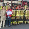 Christel und Elena Schmitt (vorne) besuchten die Einsatzkräfte der Feuerwehr in Wiesentheid und überreichten dem stellvertretenden Kommandanten Stefan Schäffel (links) einen Scheck über 250 Euro.