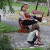 Vor dem Regen hatten die Kinder bei der Sonnwendfeuer viel Spaß mit dem Malen und Schreiben. Die Erwachsenen im Hintergrund schauen interessiert zu.