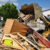 Im Bauhof wird mit einem Radlader der durch Hochwasser entstandene Sperrmüll in einen Container gekippt.