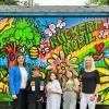 Stolz präsentieren (von links) Kinder der Klasse 3b mit Rektorin Sabrina Neckov (rechts) den bemalten Bauwagen auf dem Pausenhof der Rückert-Grundschule, den die Schweinfurter Unternehmensgruppe gespendet hat, hier vertreten von Firmenchefin Carolin Glöckle (links).