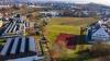 Auf dieser Wiese zwischen Berufsschule und Rainhaus (rechts) wird das neue Schulgebäude entstehen, mit Abstand zum Rainhaus. Dem projekt weichen muss die Turnhalle (unten links).