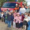 Auf dem Foto: Einige Kindergartenkinder mit ihren Betreuerinnen und Feuerwehrleuten.