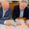 Landrat Thomas Bold (rechts) und Michael Schäder, Nahverkehrsbeauftragter des Landkreises, beim Studium des Nahverkehrsplans Mainfranken