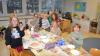 Lehrkraft Maryam Aliyeva mit Schulkindern beim Verzieren von Kiefernzapfen.