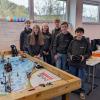 Auf dem Bild zu sehen ist neben dem Spielfeld das Team der Robogeeks mit (v.l.) Marvin Eisenmann, Selina Cerny, Lilli Rippstein, Joel Löhnert, Moritz Beck und Florian Metz, der den Roboter in der Hand hält.