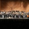 Das große symphonische Blasorchester, durch ein Klavier und fünf Streicher unterstützt, im größten Saal des CCW