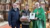 Im Bild (von links): Kirchenpfleger Claus Böhm, der langjährige Kirchenpfleger Alfred Stark und Pfarrer Rügamer, bei der Übergabe der Dankesurkunde, unterschrieben von Bischof Dr. Franz Jung und einem Präsentkorb der Kirchenverwaltung.