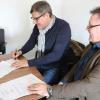 Martin Schlereth und Ralf Prosch (rechts) bei der Unterschrift unter den Kooperationsvertrag.