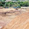 Verfüllung: Beim Blick über den Absperrungszaun erkennt man die Abbaufläche der Sandgrube, während im Hintergrund bereits mit der Verfüllung der Deponie mit Bauschutt begonnen wurde.