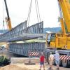 Nachdem bereits die Installierung der Ersatzbrücke für die Behelfsumfahrung über den Main zu Wochenbeginn zahlreiche Schaulustige angelockt hatte, wurde am gestrigen Donnerstag auch die Brücke für die Fußgänger und Radfahrer mit zwei Autokränen in Stellung gebracht. Die Umfahrung soll bis Monatsende fertig gestellt sein, damit die Staatsstraße 2191 in der ersten Juli-Woche gesperrt werden kann, wie Projektleiter Bernd Träger auf Anfrage mitteilte. Nach Verlegung der restlichen Gashochdruckleitungen und der Starkstromleitung (20 KV) werde der Abbruch der Mainbrücke beginnen. Anschließend folge der Neubau, beginnend mit der Gründung der Pfeiler. Bisher liegen die Arbeiten im Zeitplan. Abgeschlossen werden sollen sie bis 2016.
