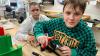 Beim Boys’ Day: Max montiert mit Felix die Bremshebel an den Lenker eines Kinderfahrrads. 