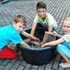 Damit das Peddigrohr schön biegsam ist, weichen Julian, Tobias und Margareta es in Wasser ein.
