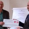 Projektleiter Stephan Seeger (li.) überreichte zum Auftakt Einrichtungsleiter Martin Pühl ein Schild, das die Beteiligung des Kathi-Baur-Alten- und Pflegeheims St. Heinrich am Projekt „achtsam handeln“ dokumentiert. FOTO: red
