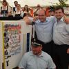 1. Vorsitzender Niklas Welscher (stehend, re.) vom Patenverein aus Trainau überraschte die FFW Unterlangenstadt mit Kommandant Sascha Rauh (kniend) und 1. Vorsitzendem Jan Millitzer (stehend, li.) mit dem Jubiläumsgeschenk.