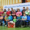 Ehrung der besten Wettbewerbsteilnehmer: stellvertretender Landrat Helmut Fischer (li.),  Ulrich Klein (re.), Kreisverbandsvorsitzender der Genossenschaftsbanken, Malte Hornung (hinten, fünftes Kind von re.) und die regionalen Preisträger des Jugendwettbewerbs.