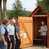 Geschäftsführerin Dr. Anne Schmitt zeigt das Innenleben der Trockentoilette.  (v. li.) Wolfgang Lilie und Hermann Lieb vom Städtischen Bauhof, Hans Bramann, Bürgermeister Jürgen Kohmann, Raimund Schlenk, Dr. Anne Schmitt, Karl-Heinz Jäger und Anne Maria Schneider.